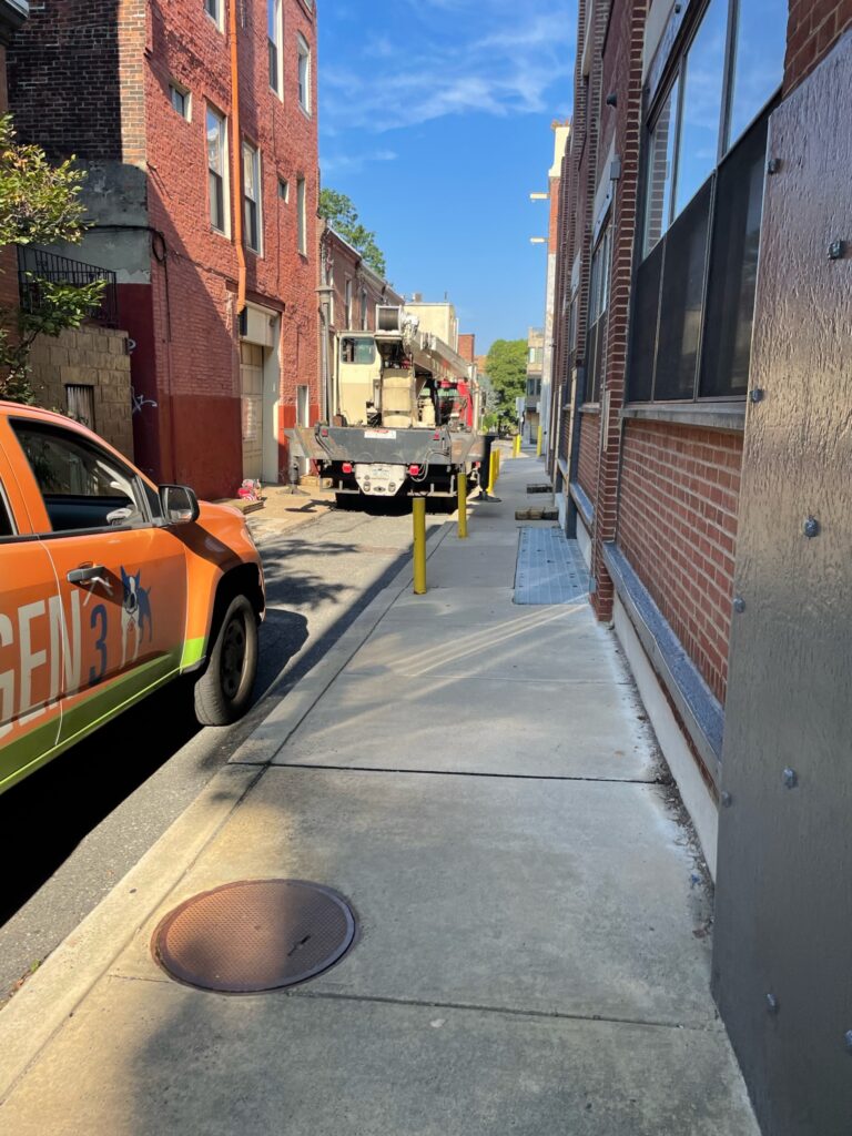 Crane in alley with GEN#3 Truck delivering HVAC Equipment