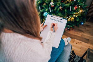 Woman writing down her New Year's Goals