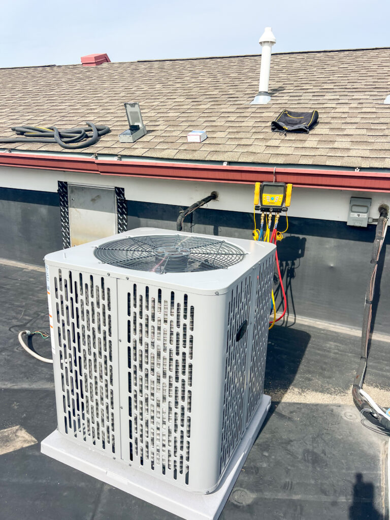New high-efficiency rooftop AC condenser installed by GEN3 Electric & HVAC in Philadelphia, with testing gauges connected during the final setup